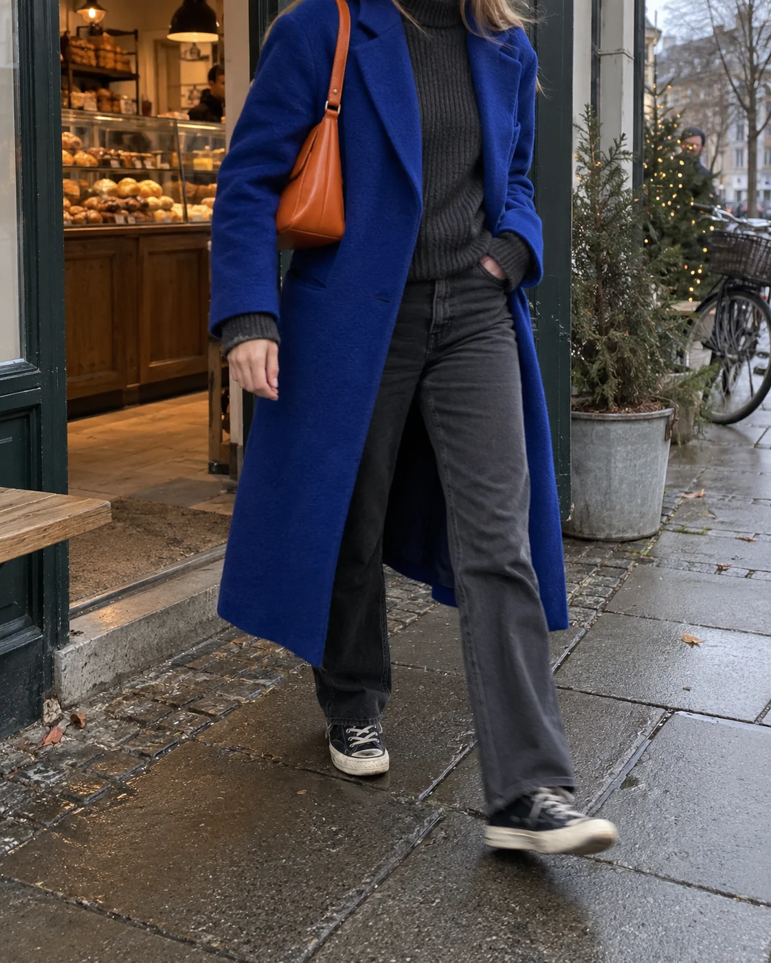 The orange bag. Cobalt coat, dark knit and worn jeans: reasonably calm so far. The orange bag arrives when another colour wasn't needed. That's why it works.