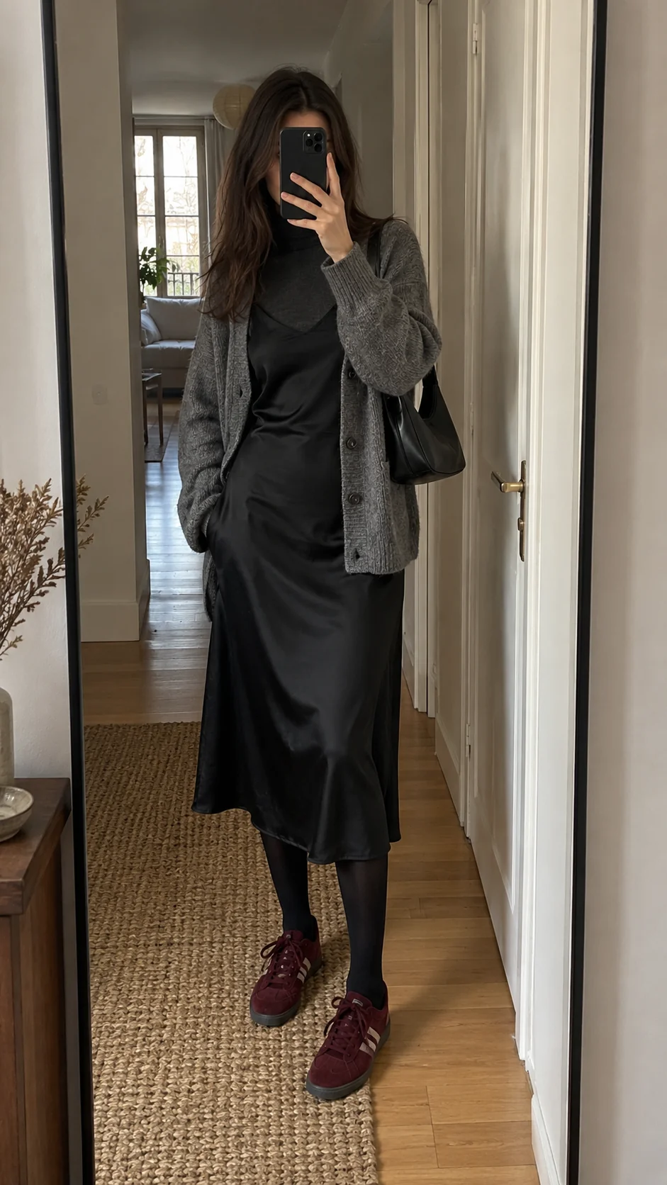 Satin, before leaving. The satin dress doesn't wait for night. A rollneck, cardigan and burgundy trainers take it out of the house in broad daylight.